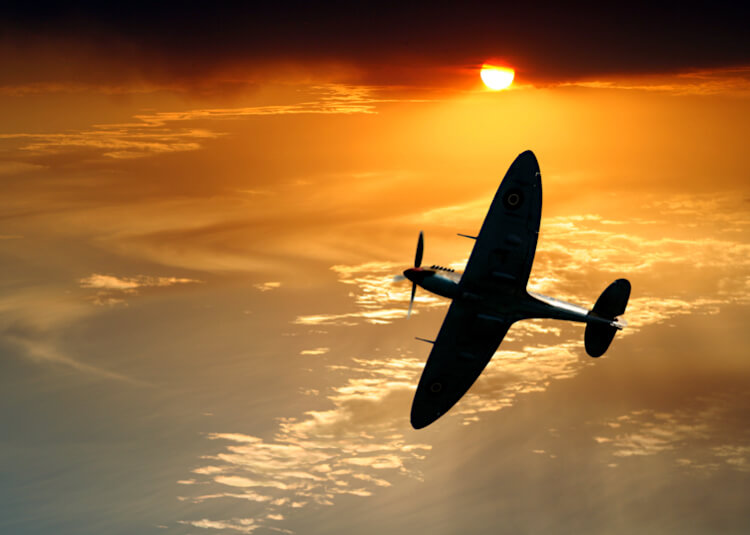 Spitfire flying in sunset sky set feature
