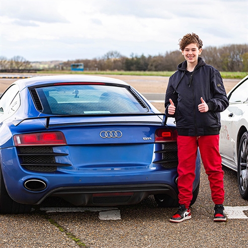 Boy with thumbs up standing next to Audi Thumbnail