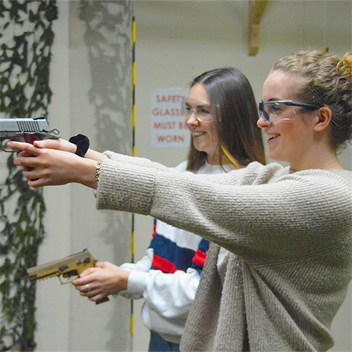 Duo shooting pistols at gun range Duo shooting pistols at gun range