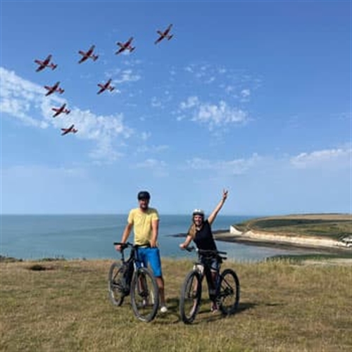 Ebike Hire Sussex - Couple on Ebikes with Planes in Background
