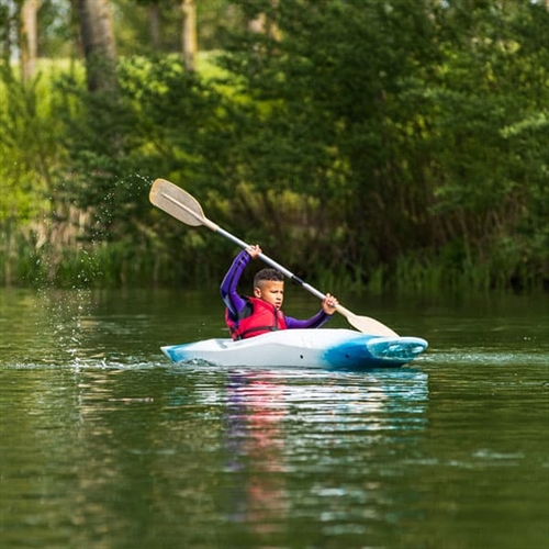 Boy paddling down river Boy paddling down river