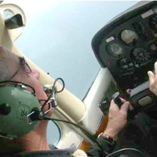 man at controls of aircraft with headphones